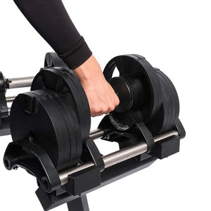 Person adjusting weight plates on a barbell stand with a white background