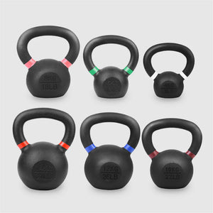 Set of six black kettlebells with color-coded weight markings on a light gray background