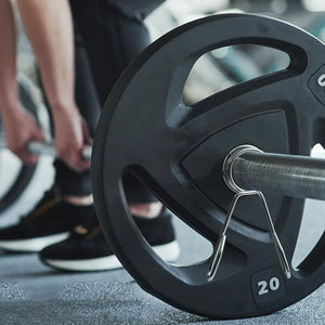 Close-up of a barbell with weight plates in a gym setting
