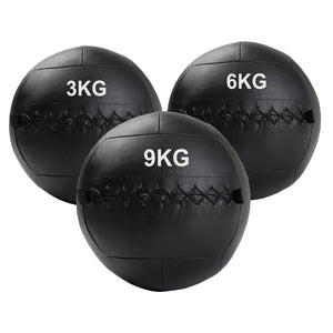 Three black wall balls with weight markings on a white background