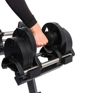 Person adjusting weight plates on a barbell stand with a white background