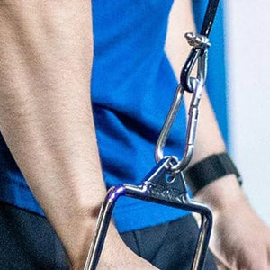 Close-up of a person wearing a blue shirt with a metal clip attached to their wrist.
