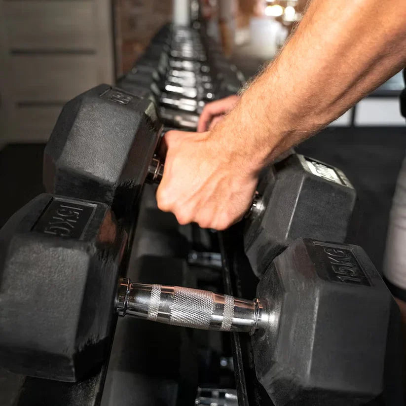 Person holding dumbbells with a dark background