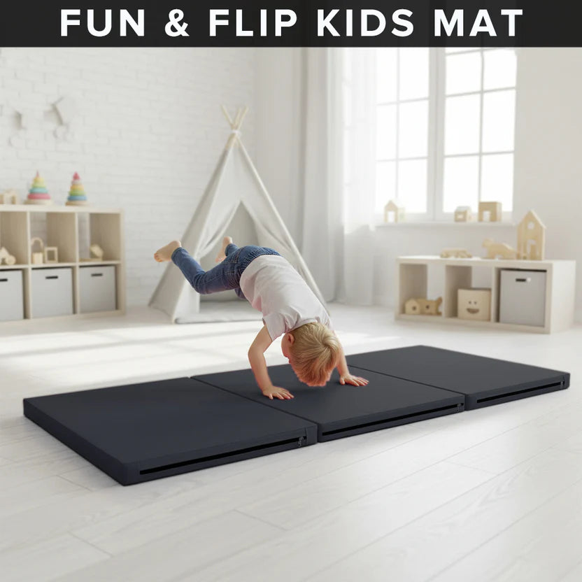Child playing on a black 'Fun & Flip Kids Mat' in a bright room with toys and furniture.