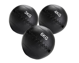 Three black weighted medicine balls with weight markings on a white background